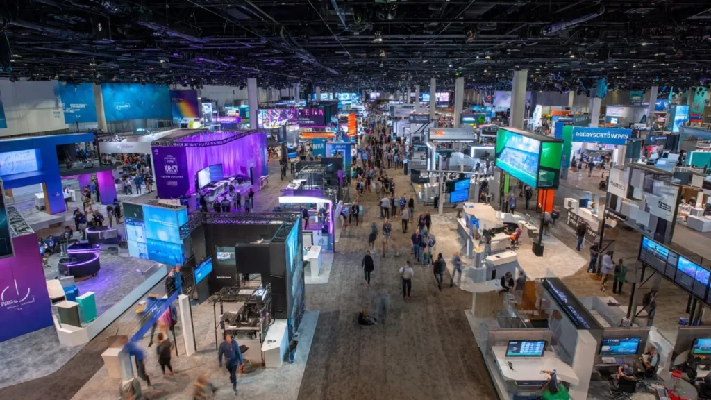 Crowded expo hall at technology conference showing vendor booths and networking opportunities